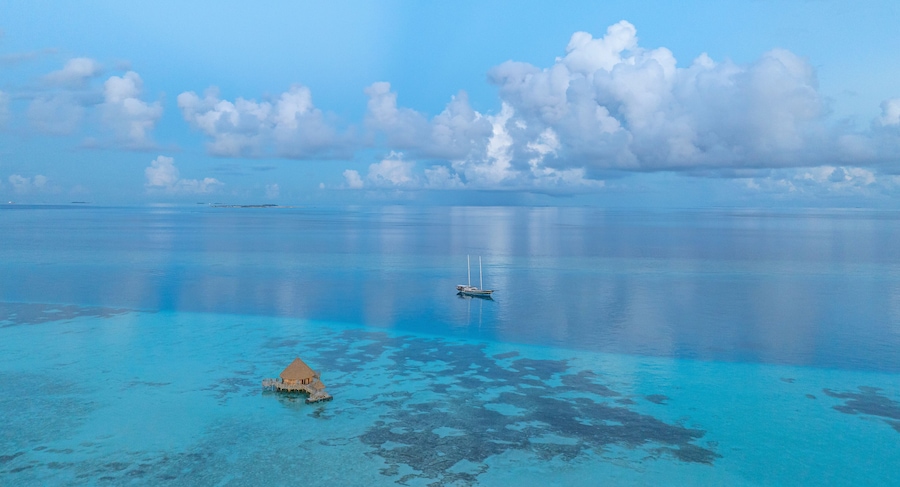 Aerial view of beautiful tropical island Amingiri with turquoise water and sandy beach, Male Atoll, Maldives.
