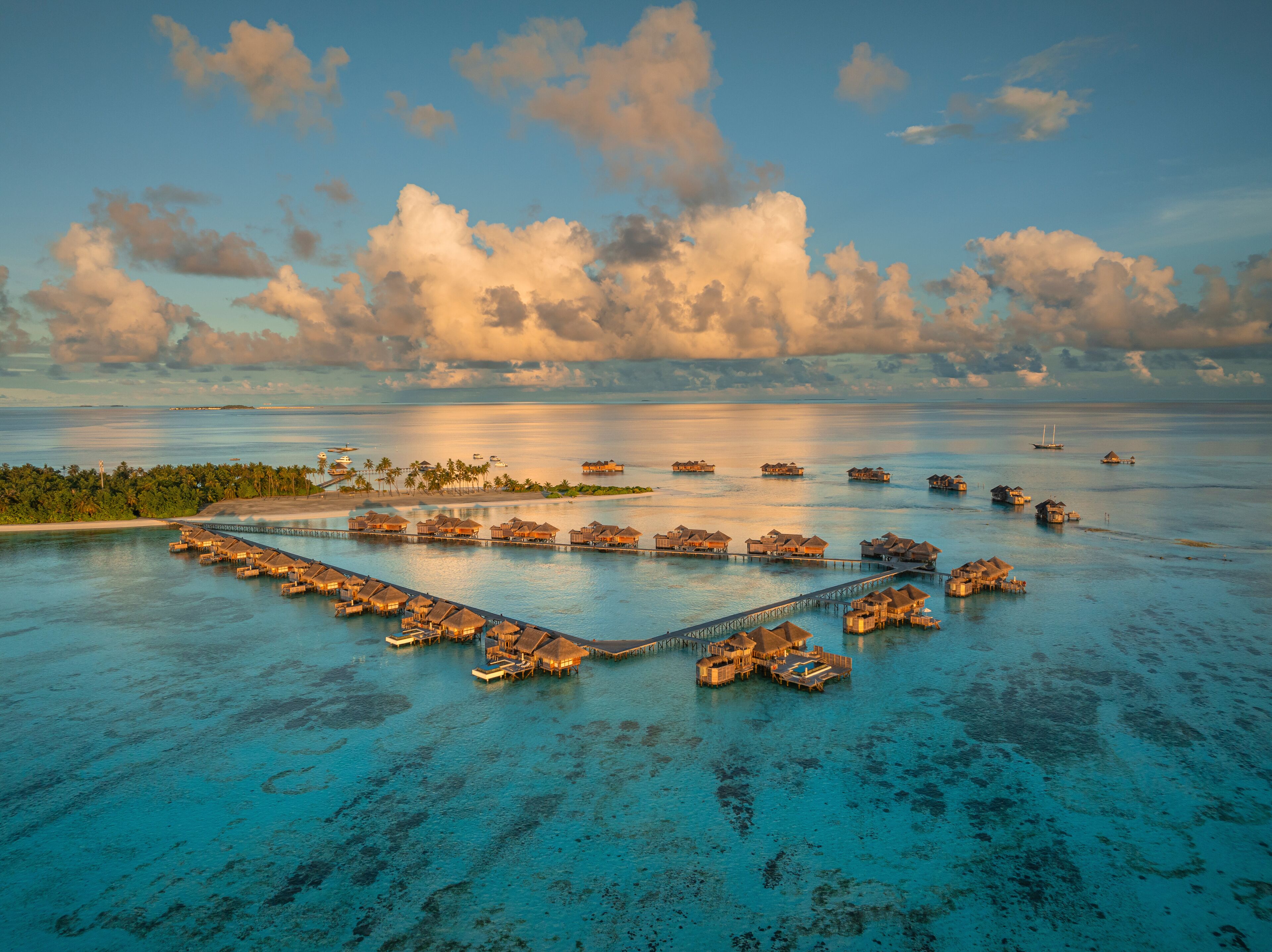 Aerial view of the beautiful tropical island resort with luxurious bungalows and turquoise ocean, Amingiri, Male Atoll, Maldives.