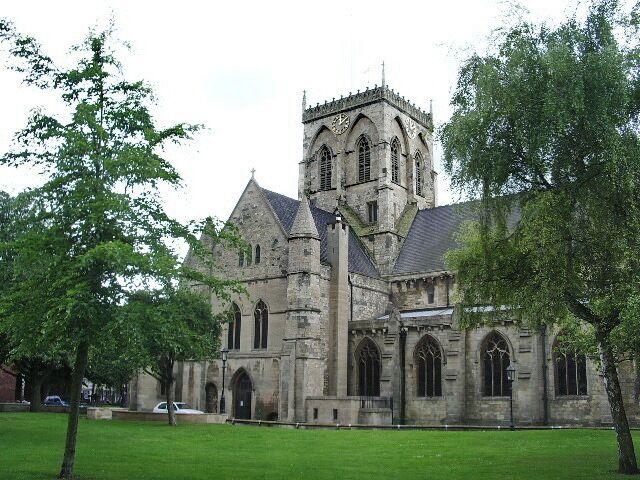 A historic stone church with a tall tower and arched windows.