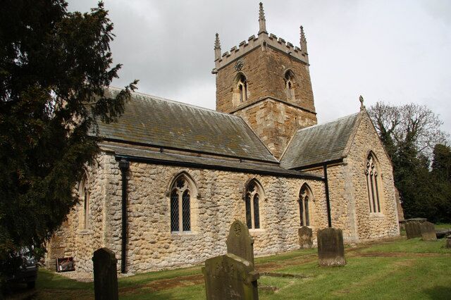 A stone church with a bell tower and a graveyard.