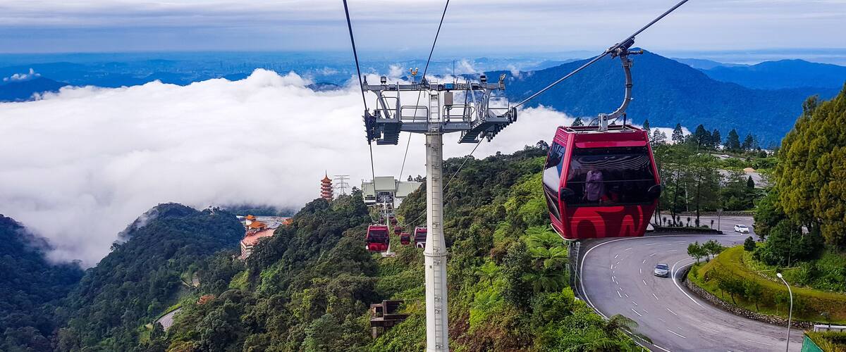 cable car at genting highlands, malaysia in a foggy weather with green grass visible from inside cable car