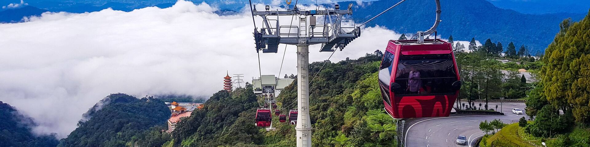cable car at genting highlands, malaysia in a foggy weather with green grass visible from inside cable car