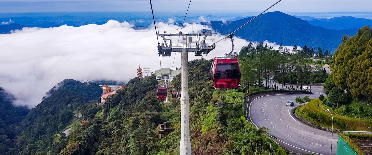cable car at genting highlands, malaysia in a foggy weather with green grass visible from inside cable car