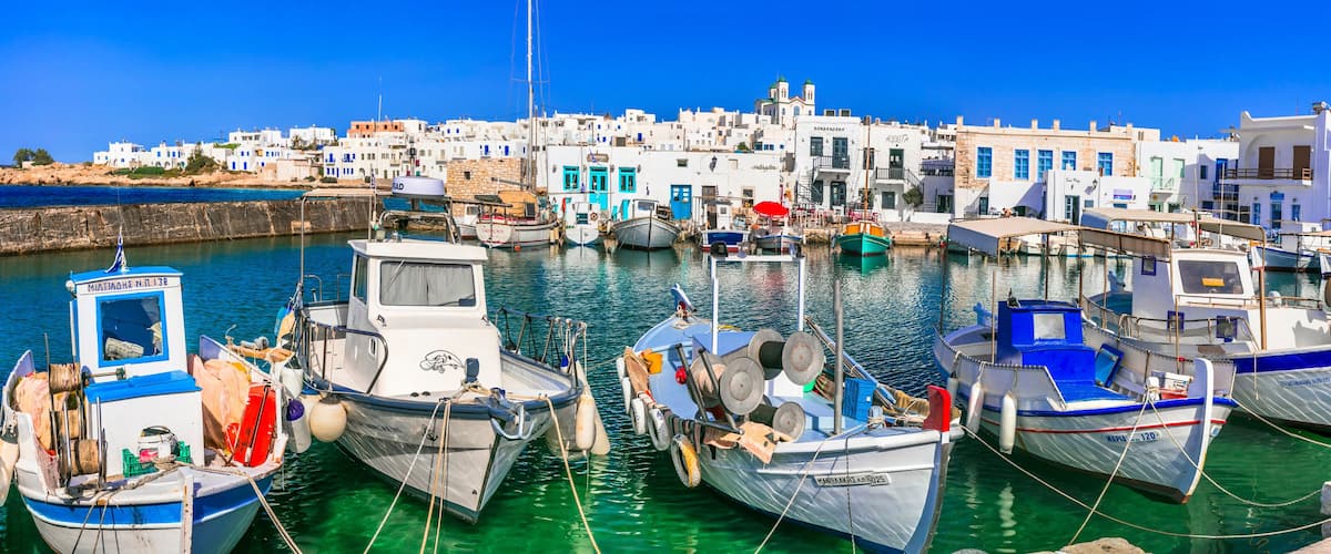 Greece travel. Cyclades, Paros island. Charming fishing village Naoussa. view of old port with boats and street taverns by the sea. may 2021