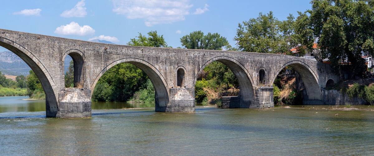 The Bridge of Arta. A stone bridge that crosses the Arachthos river in the west of the city of Arta in Greece. Sunny day with blue sky
