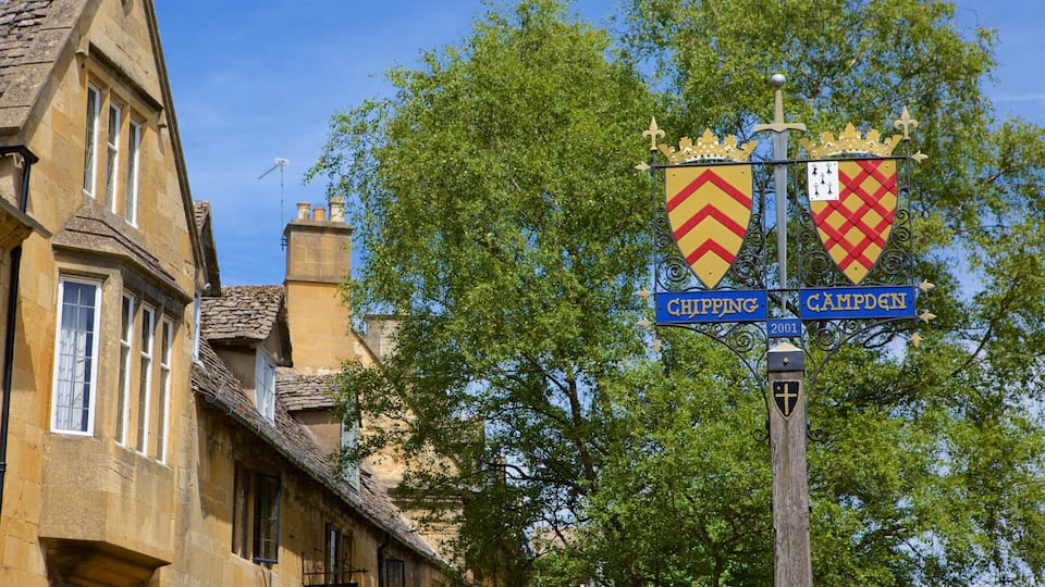 A street sign with two shields, one labeled 'Chipping' and the other 'Camden', mounted on a pole with a cross at the top.