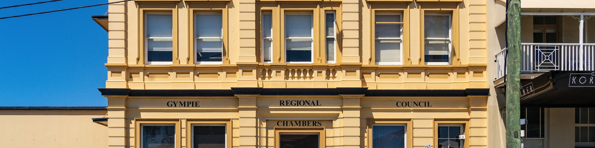 A colorful sunlit historic building on the side of a sloping street