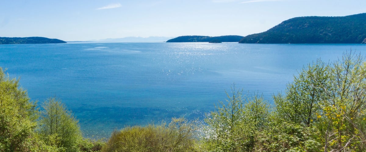 A calm lake surrounded by green hills.