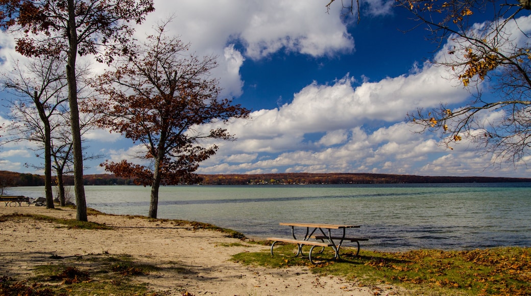 Sunny autumn day on empty beach with picnic table at Higgins Lake State Park in Michigan.