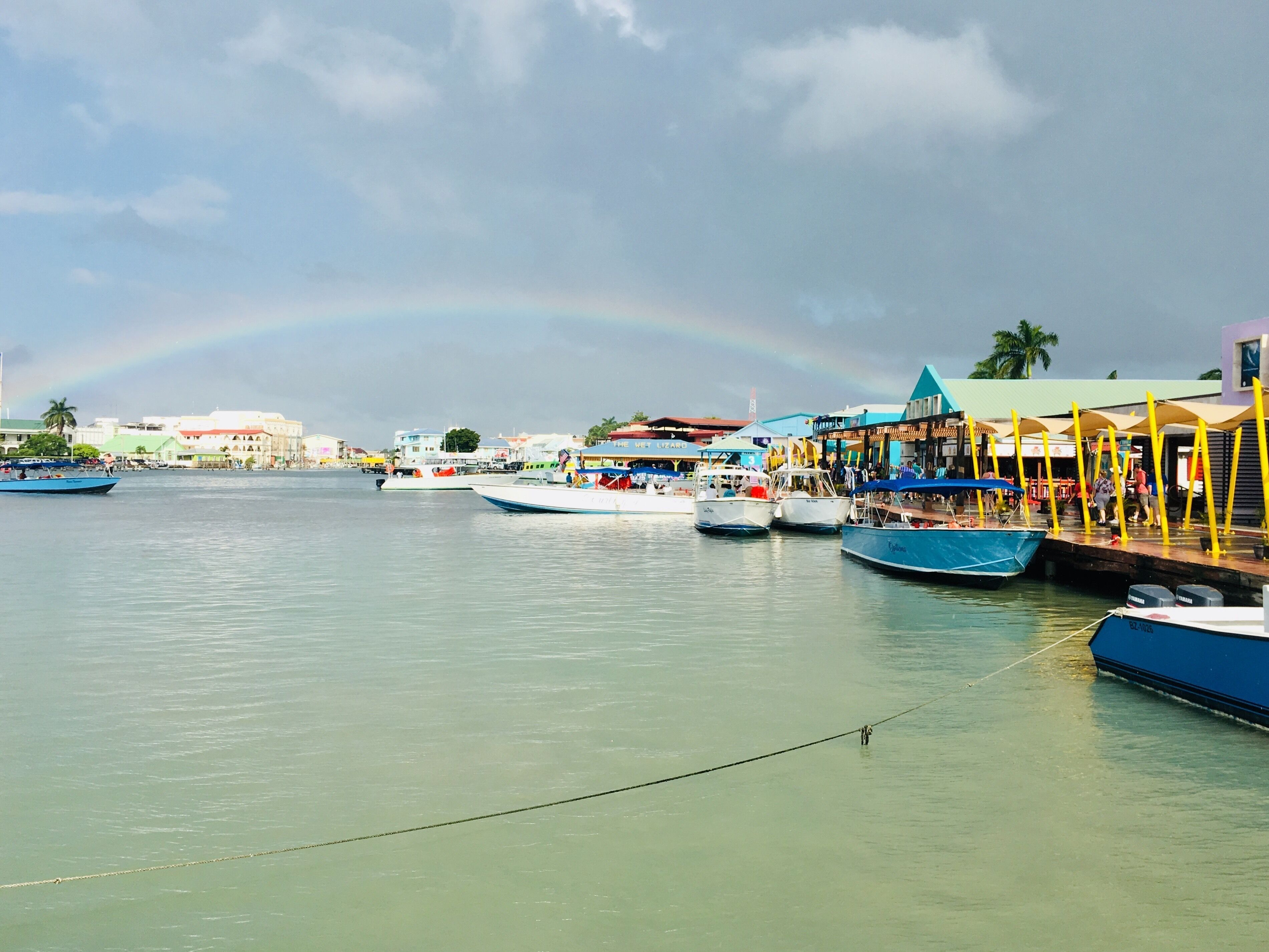 As soon as we reached the dock, it started to shower. The sun created this beautiful rainbow, which melted perfectly into the colorful Belize City. #culture #belize