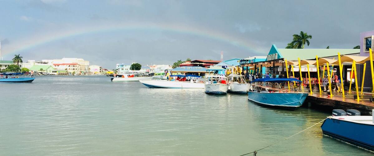 As soon as we reached the dock, it started to shower. The sun created this beautiful rainbow, which melted perfectly into the colorful Belize City. #culture #belize