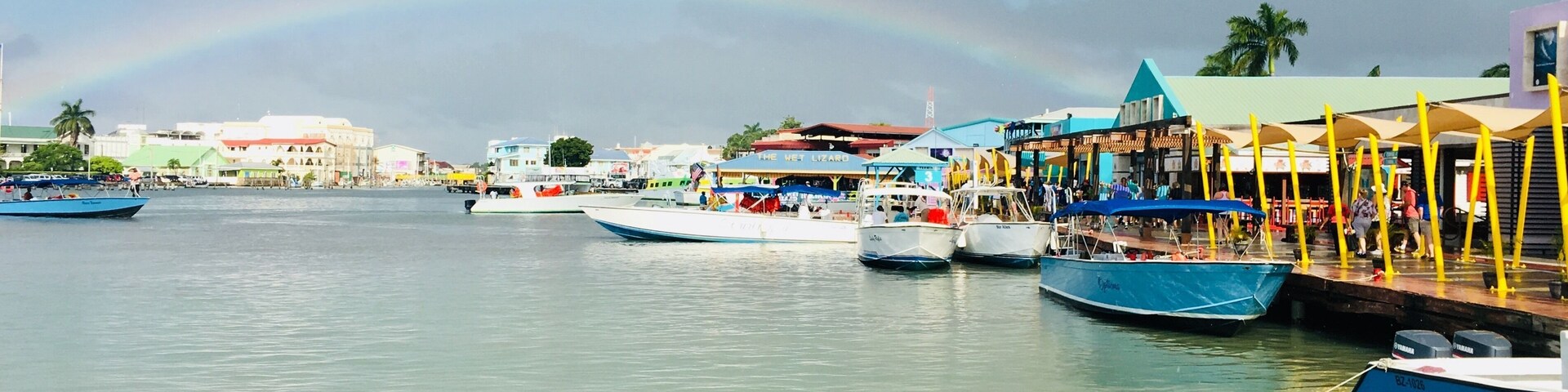 As soon as we reached the dock, it started to shower. The sun created this beautiful rainbow, which melted perfectly into the colorful Belize City. #culture #belize