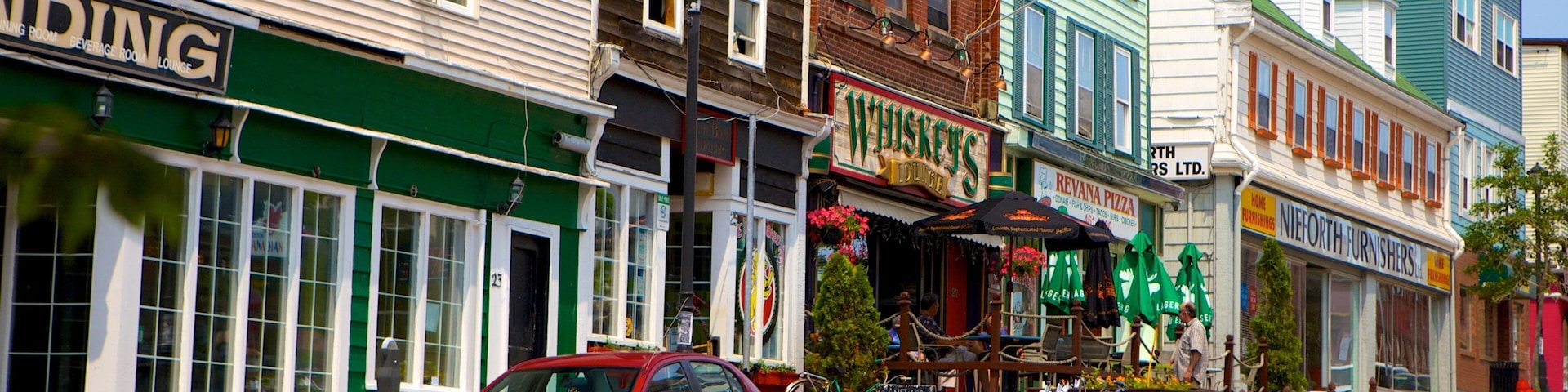 A street lined with colorful buildings, including a whiskey lounge and a furniture store.