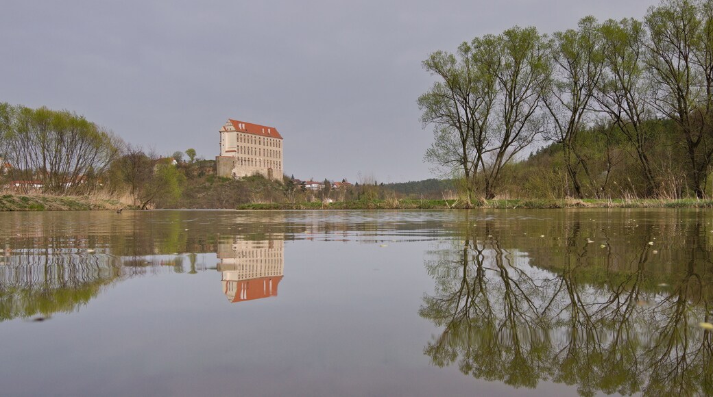 Historical Plumlov castle from 17th century and reflection on the surface of the pond in Prostejov district in Czech republic. Cloudy smoke fog air pollution sky.