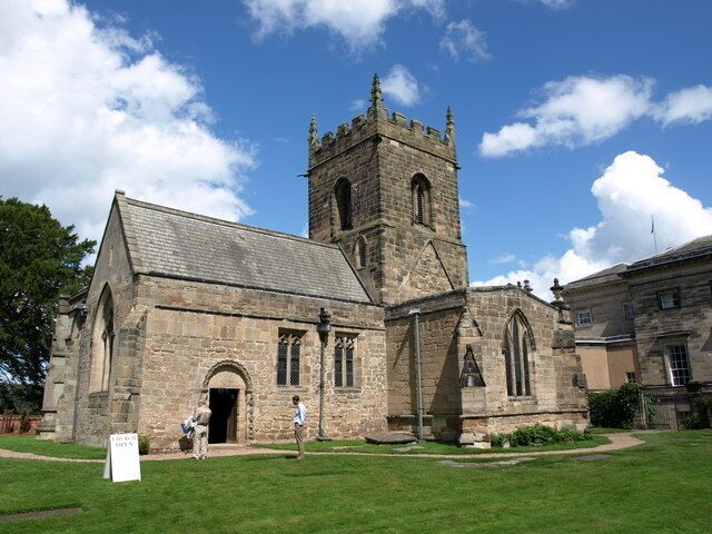 A historic stone church with a prominent tower and arched windows.