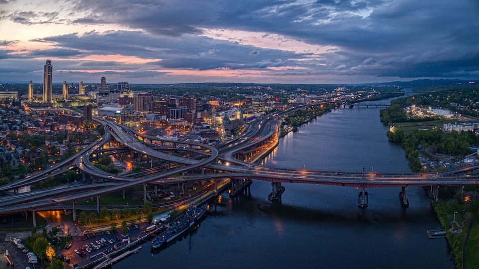 A cityscape with a river, multiple bridges, and a prominent skyscraper.