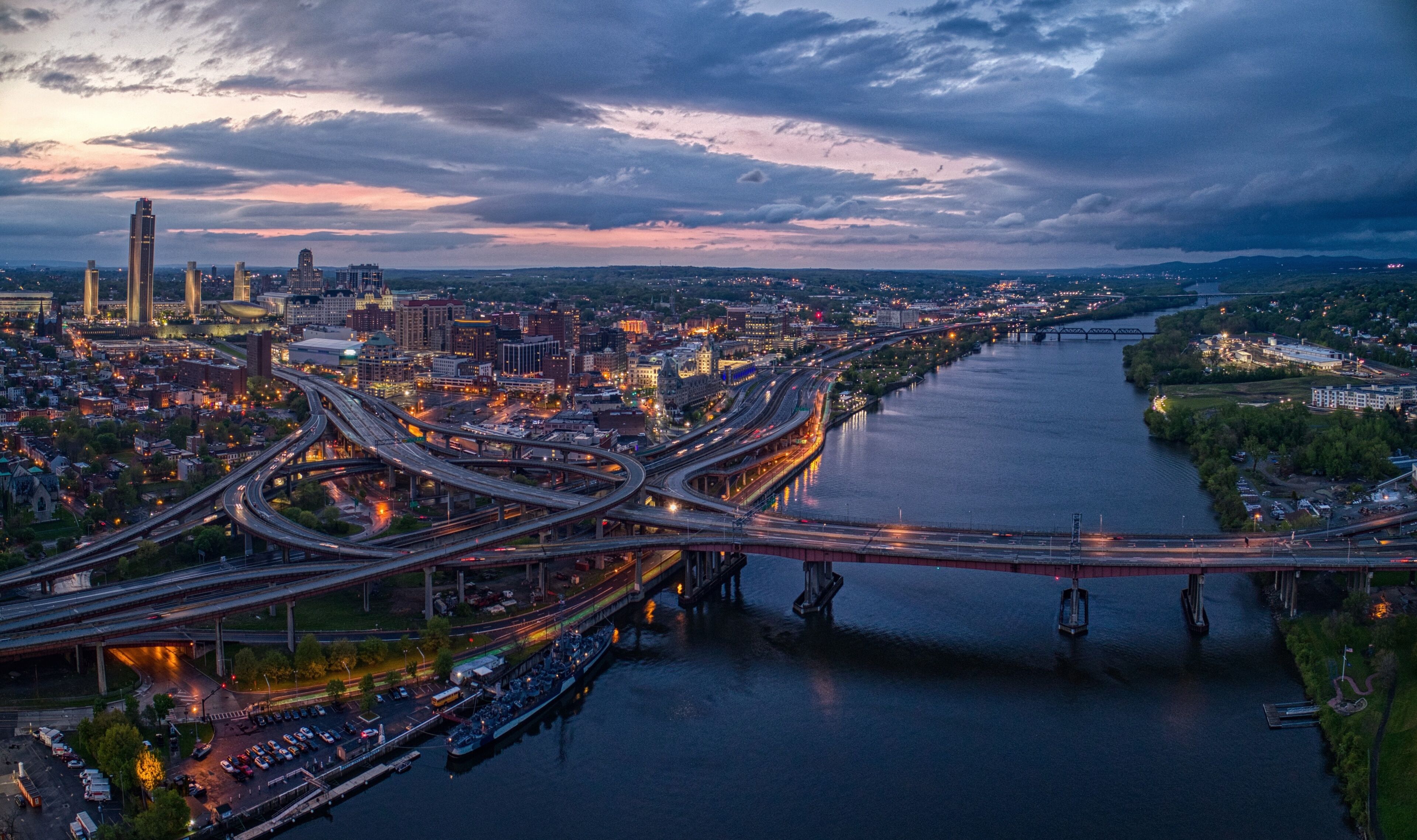 A cityscape with a river, multiple bridges, and a prominent skyscraper.
