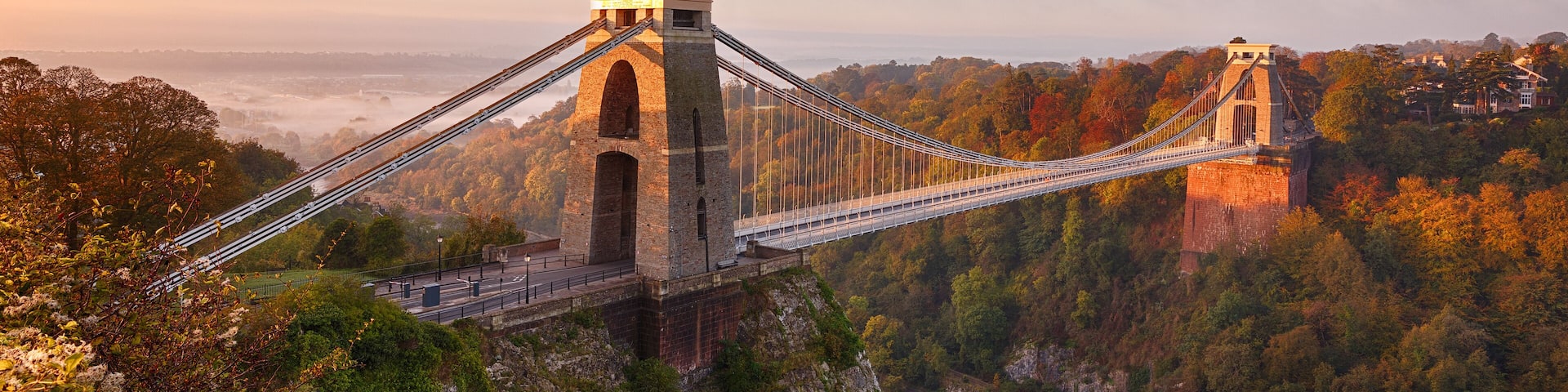 Clifton Suspension Bridge on an autumn morning as the sun rises and breaks through the clouds