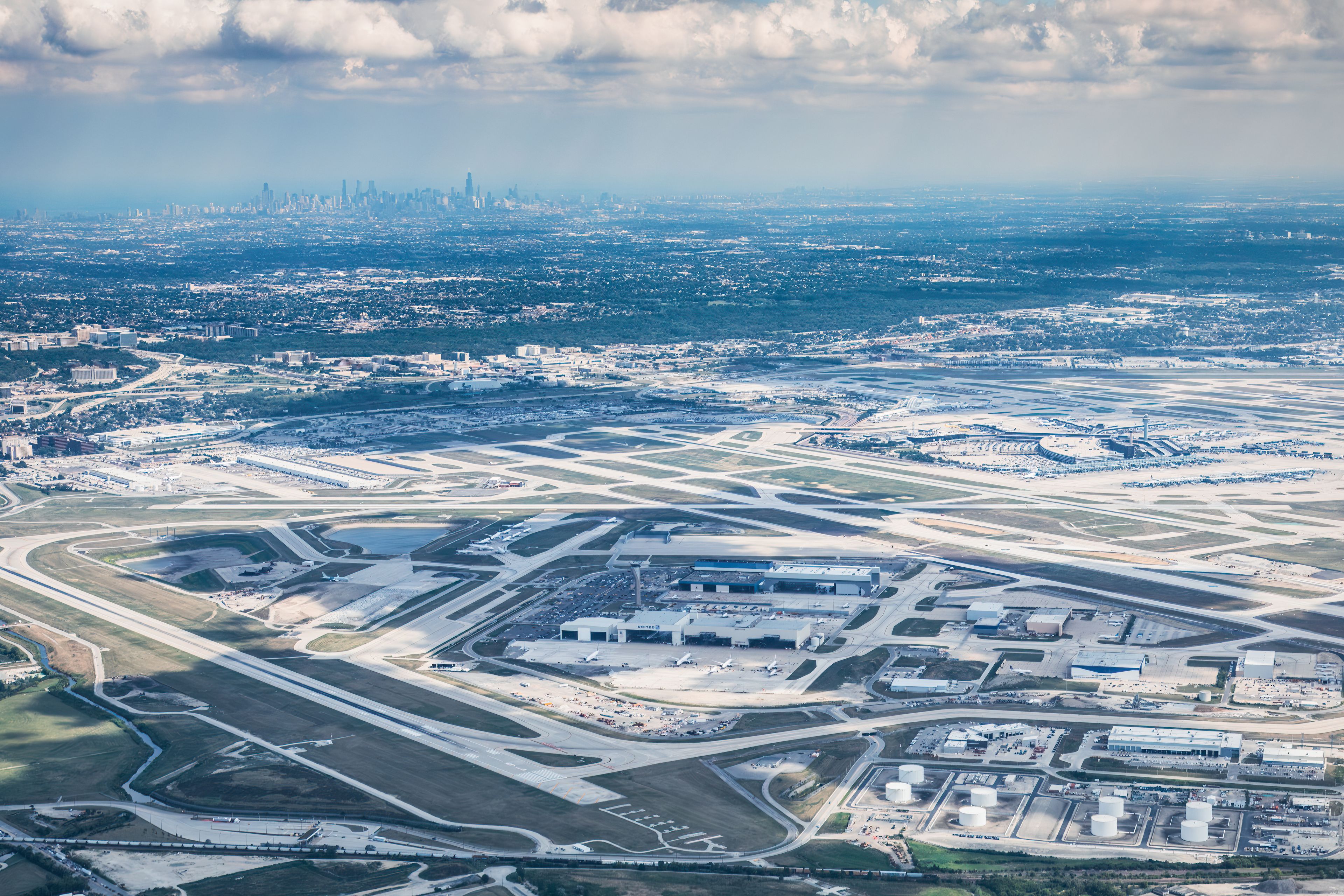 Aerial view of an airport with the city skyline in the background.
