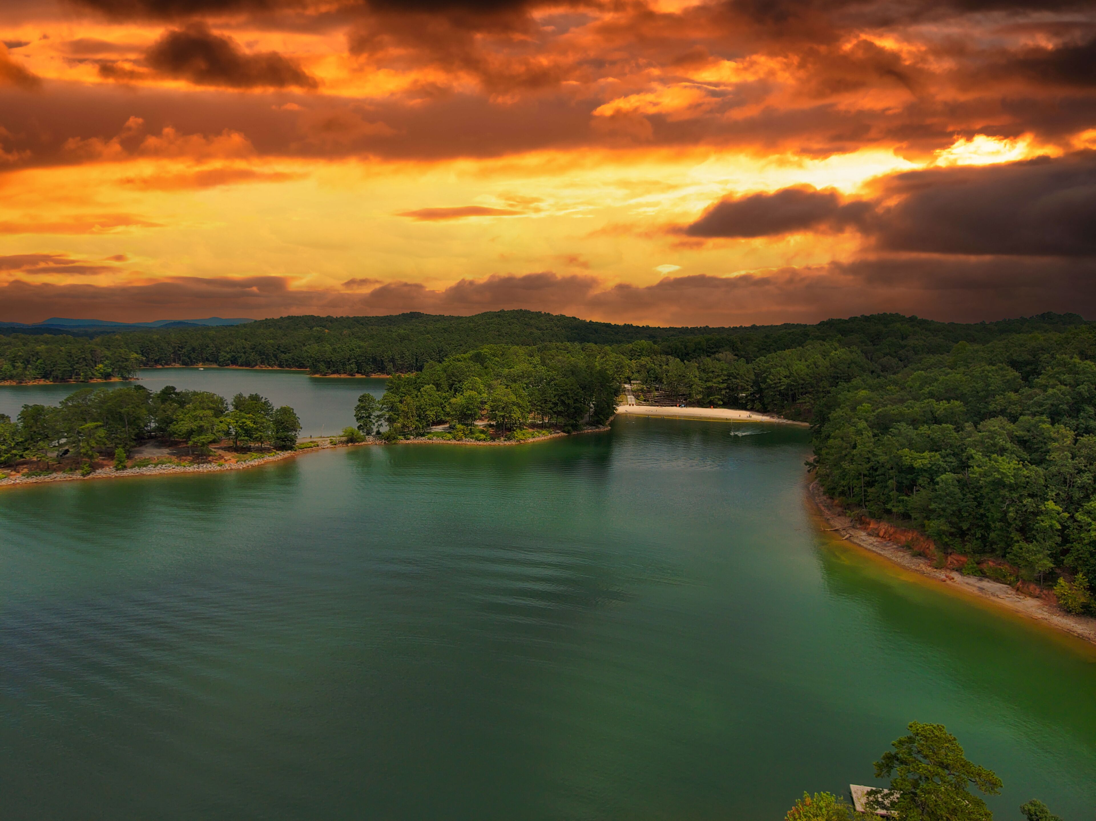 A river winding through a forested landscape with a beach on one side.