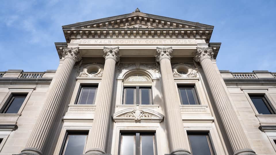 The facade of the Kalb County Court House with classical columns and a pediment.