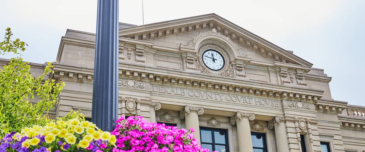 A building with columns and a clock, labeled 'DEKAIB COUNTY COURT HOUSE.'