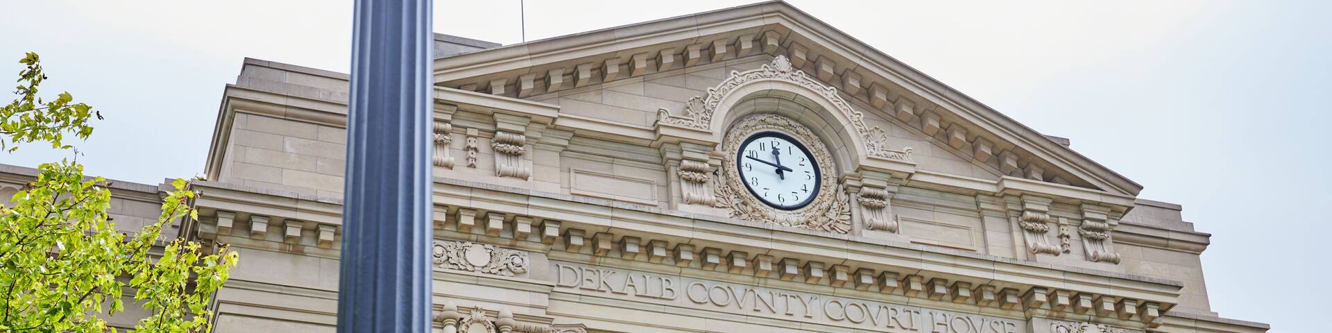 A building with columns and a clock, labeled 'DEKAIB COUNTY COURT HOUSE.'