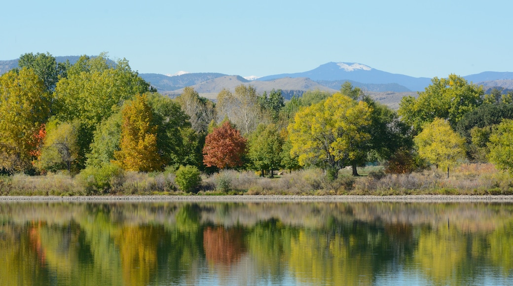 Colorado lake landscape with autumn trees with reflection and view of snow on Rocky Mountain foothills in background