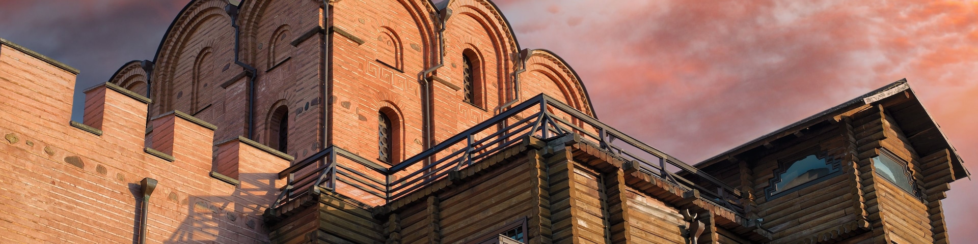 Ein historisches Gebäude mit einer markanten Kuppel und Bogenfenstern vor einem beeindruckenden Abendhimmel.