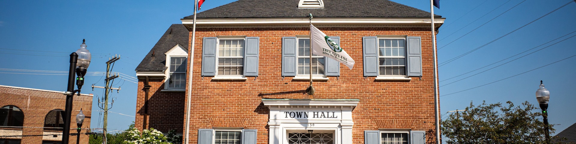 City Hall in Herndon, Virginia, with flags and blue sky.