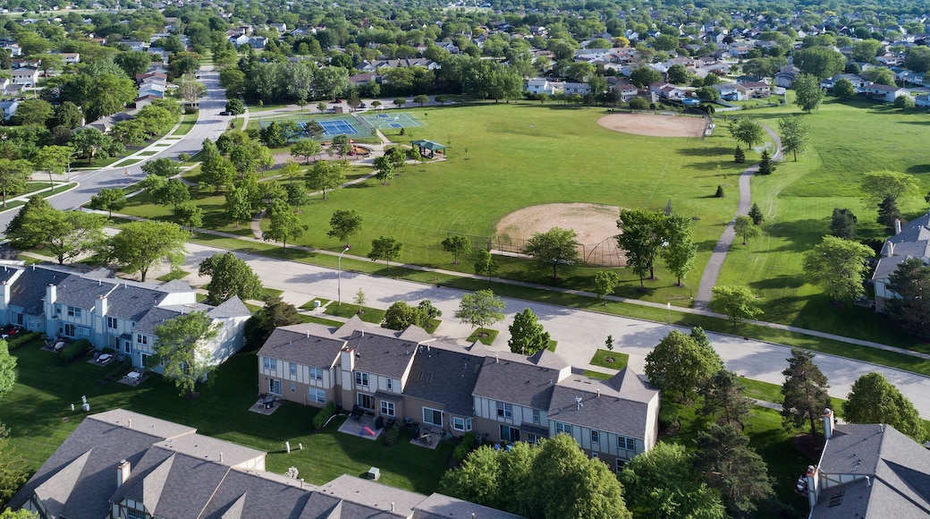 Zona residencial con casas, un parque con un campo de béisbol y una cancha de tenis.