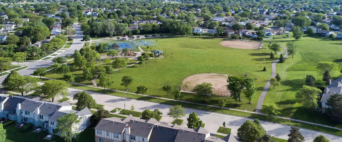 A residential area with houses, a park with a baseball field, and a tennis court.