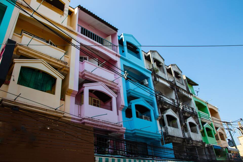 A row of colorful buildings with balconies and a clear blue sky.