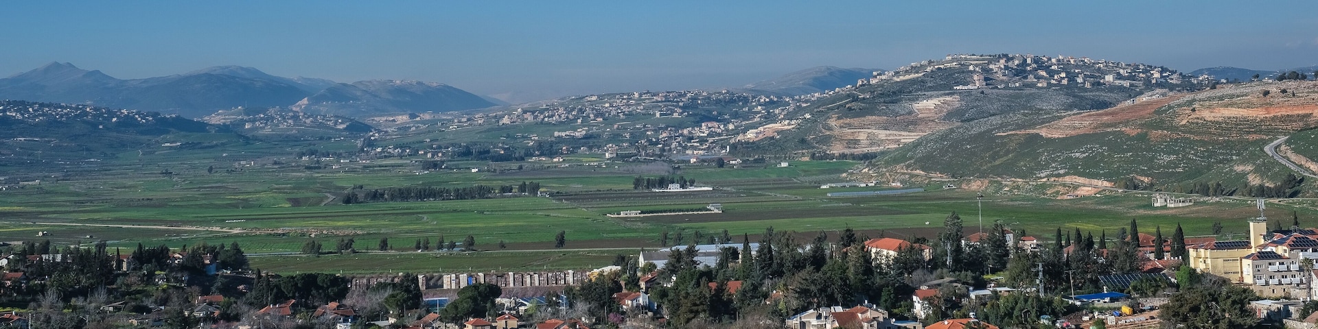View of the town of Metula, situated on the Israeli-Lebanese border, at the foot of Mount Hermon (in the background), as seen from Dado lookout point, Upper Galilee, Israel.
