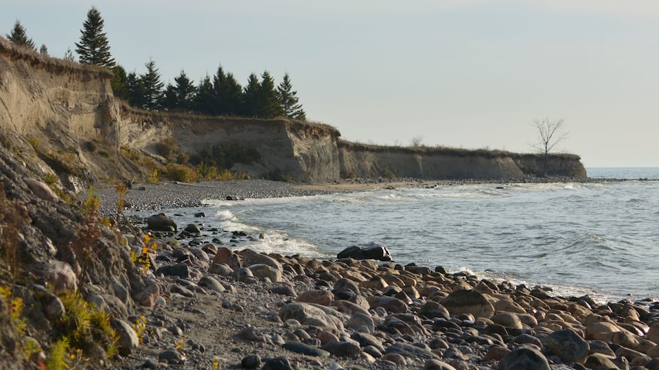 A rocky shoreline with cliffs and sparse vegetation.