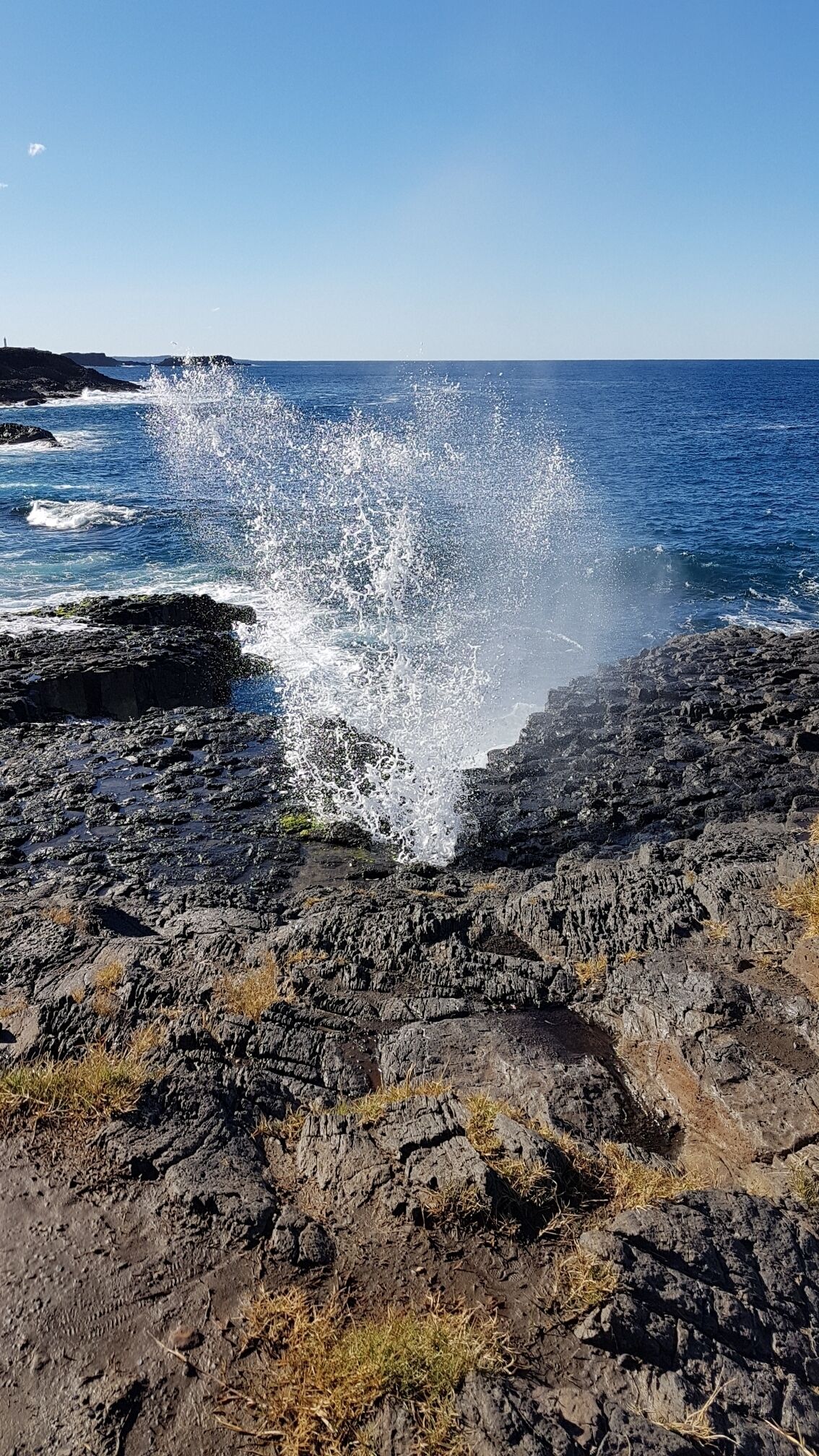 A rocky coastline with waves crashing against the rocks.