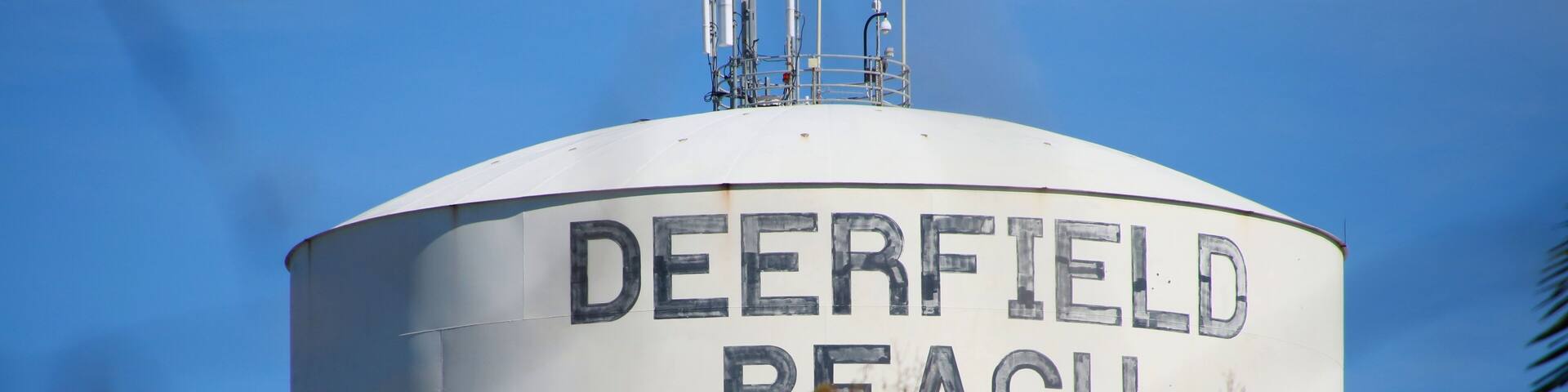 Deerfield Beach Water Tower Obscured by Out-of-Focus Branches against Clear Blue Sky in January