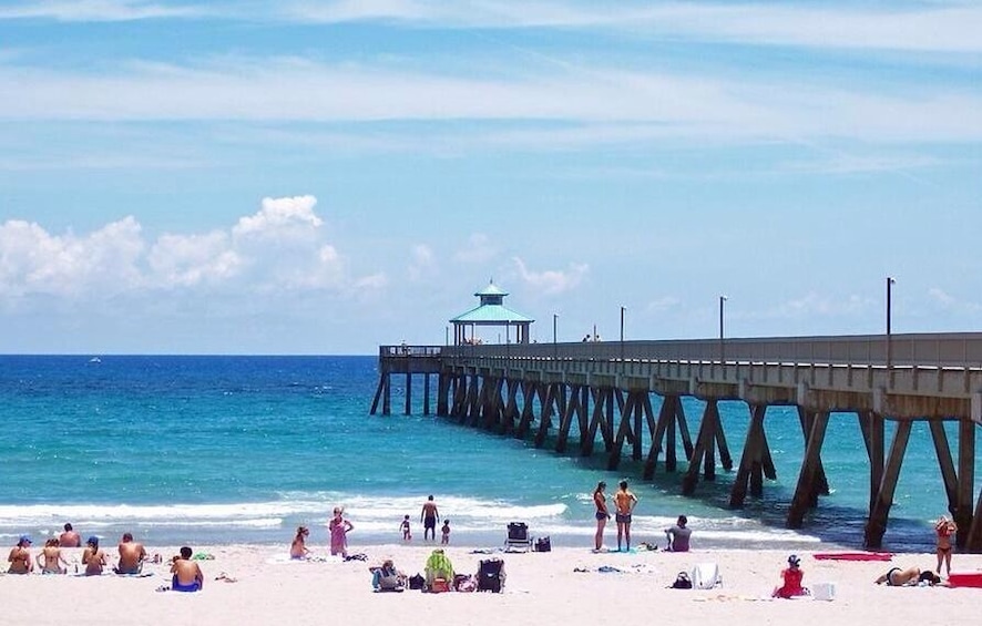 A beach with a pier extending into the ocean.