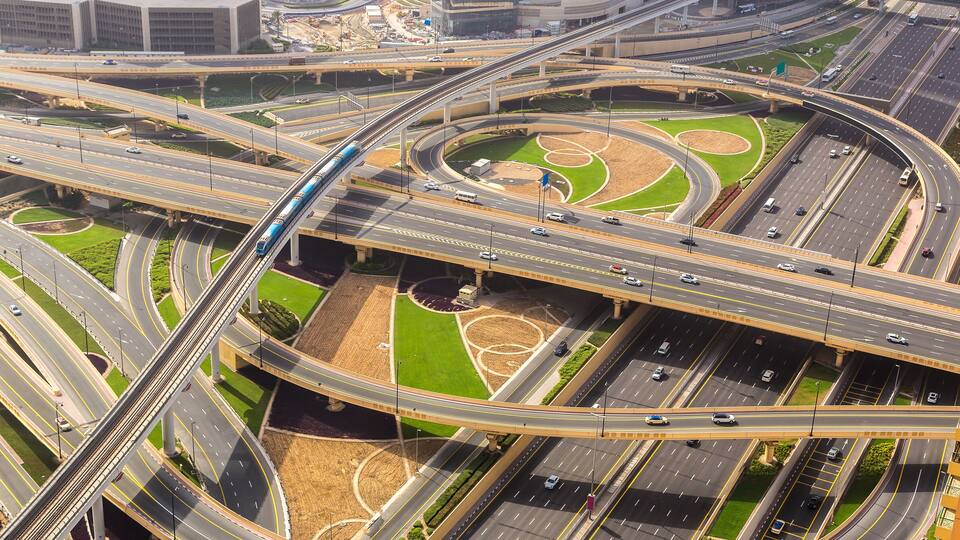 A complex highway interchange with multiple overpasses and green spaces.