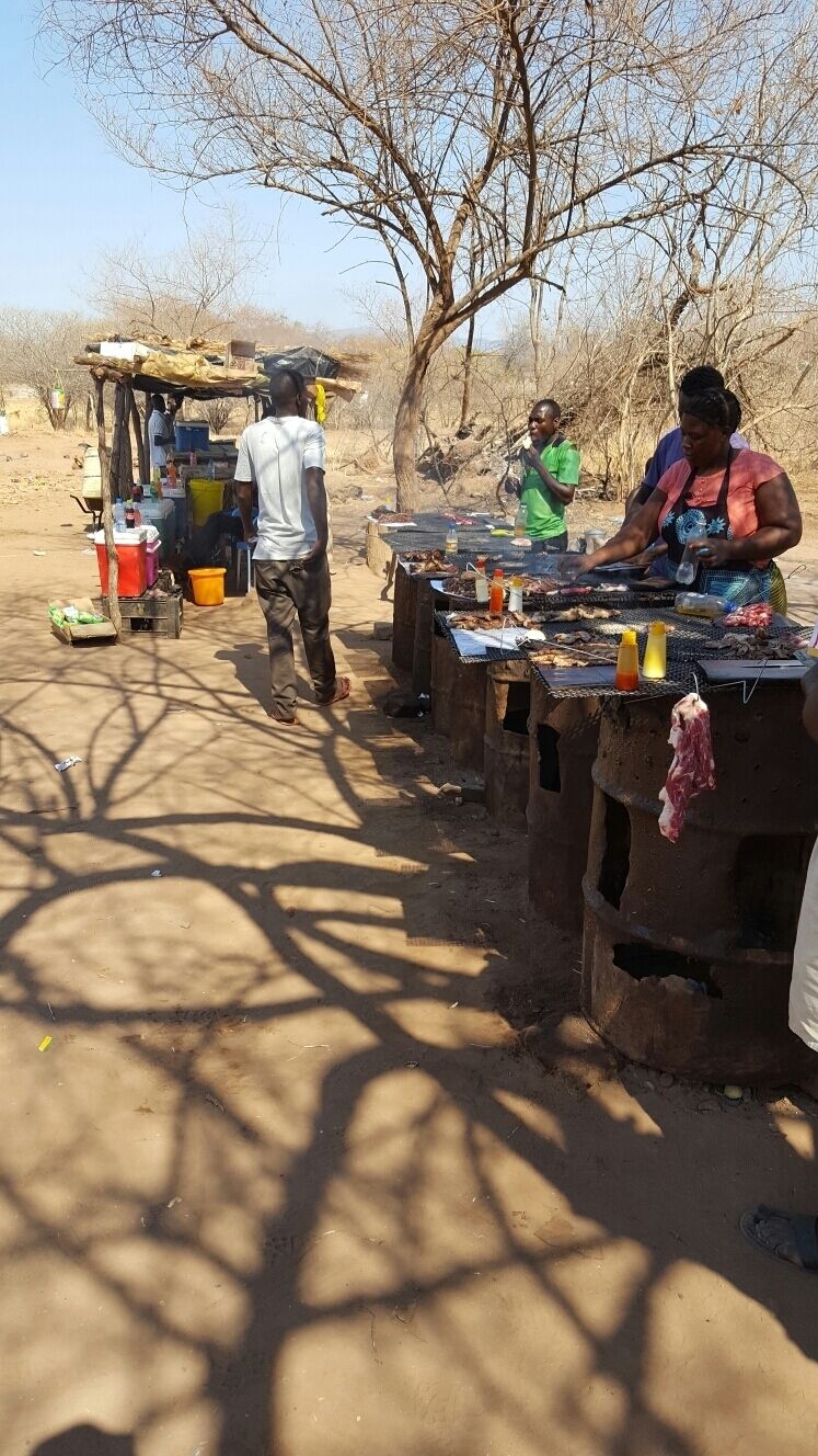 A market scene with people cooking and selling food.