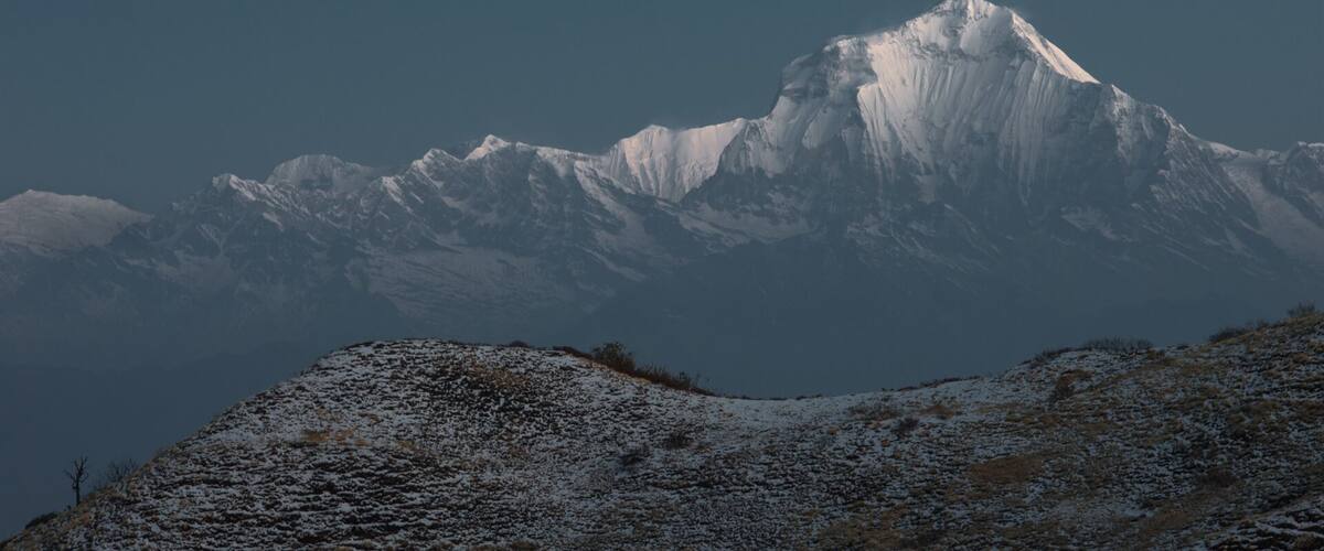 A snow-covered mountain range with a prominent peak.