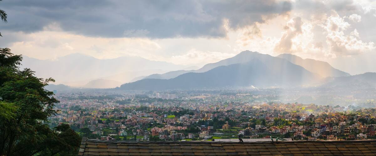 A cityscape with mountains in the background.