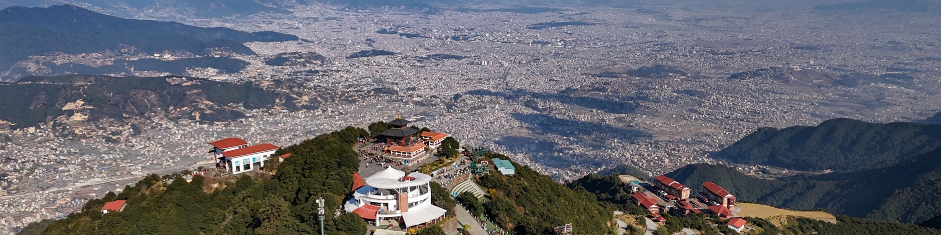 Aerial view of Chandragiri Hills Resort nestled amidst lush greenery, overlooking Kathmandu Valley under a clear sky, Chandragiri, Bagmati Province, Nepal.