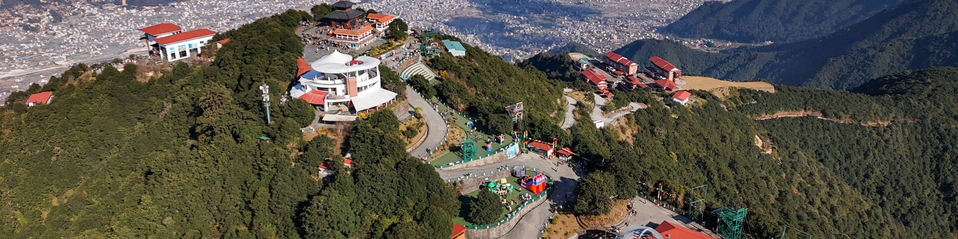 Aerial view of Chandragiri Hills Resort, with its red-roofed structures nestled amidst lush greenery, overlooking the sprawling cityscape, Chandragiri, Bagmati Province, Nepal.