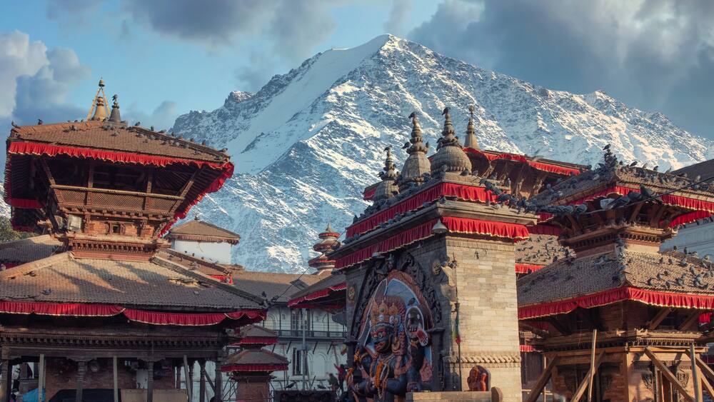 Traditional Tibetan architecture with snow-capped mountains in the background.