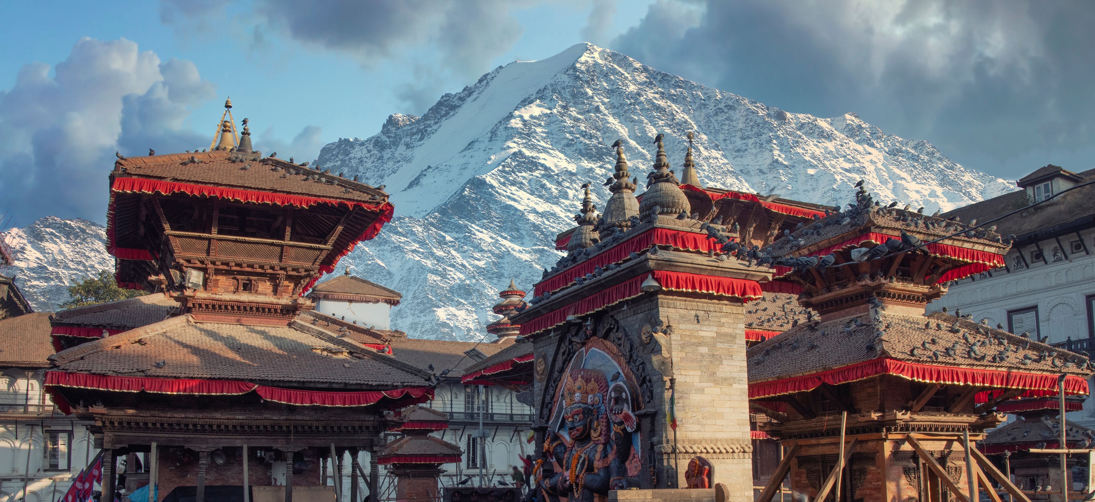 Traditional Tibetan architecture with snow-capped mountains in the background.