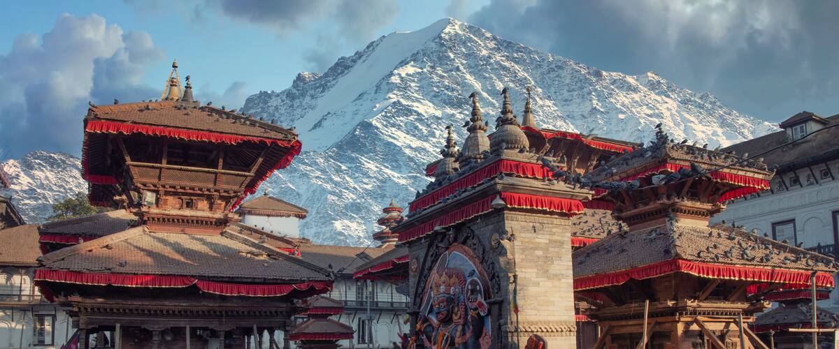 Traditional Tibetan architecture with snow-capped mountains in the background.