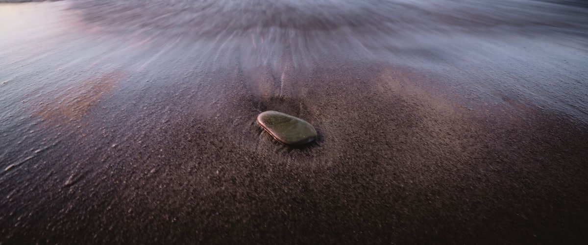 Una playa con olas y una tabla de surf en la arena.