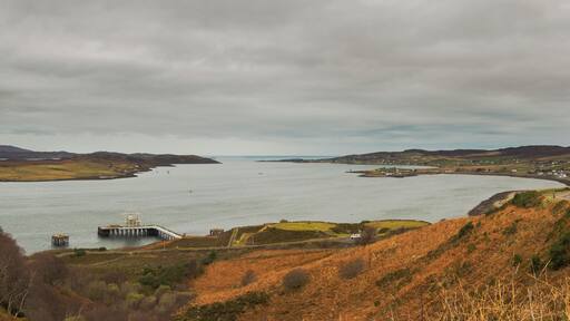 Panorama overlooking Loch Ewe. The NATO Petroleum, Oil and Lubricants (POL) depot can be seen in the foreground; the villages of Aultbea, Ormiscaig and Mellon Charles are visible along the Western shore of the loch (right hand side); North of the POL depot is the Isle of Ewe and in the background on the left hand side behind the island, part of the Eastern shore are visible, including the beach at Firemore.