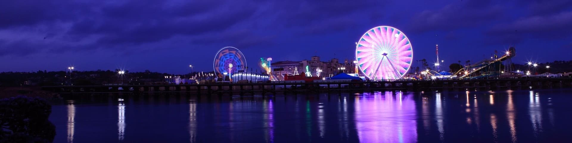 A Ferris wheel and a water body at night.